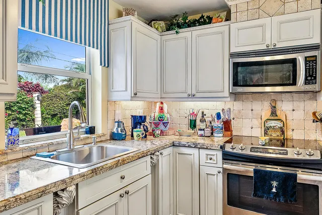 a kitchen with stainless steel appliances granite countertop a sink stove and microwave