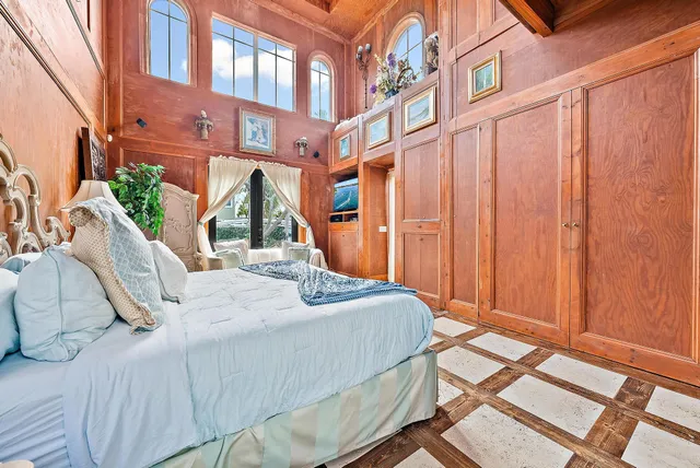 a bedroom with a bed and a large window