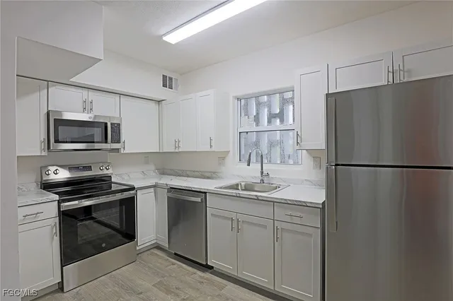 a kitchen with a sink stove and microwave