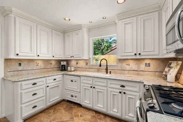 a kitchen with white cabinets and white appliances