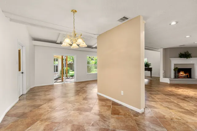 a view of a livingroom with a chandelier fireplace and window
