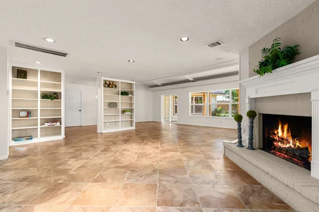 a view of an empty room with a fireplace and a window