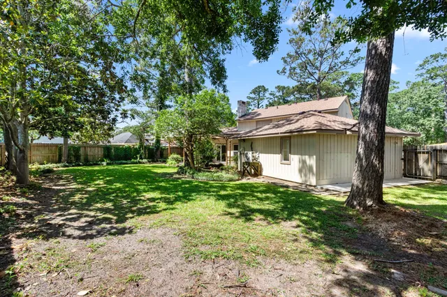 a view of a house with a yard tree and a table