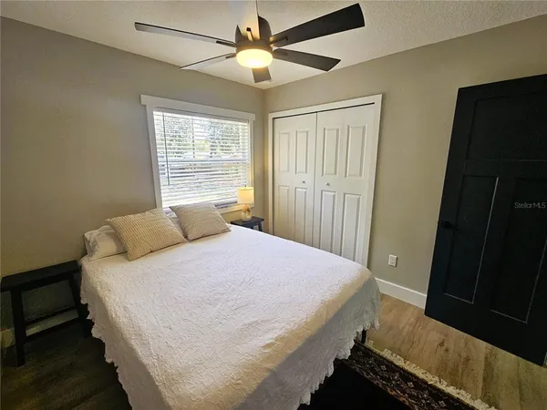 an empty room with wooden floor chandelier fan and closet