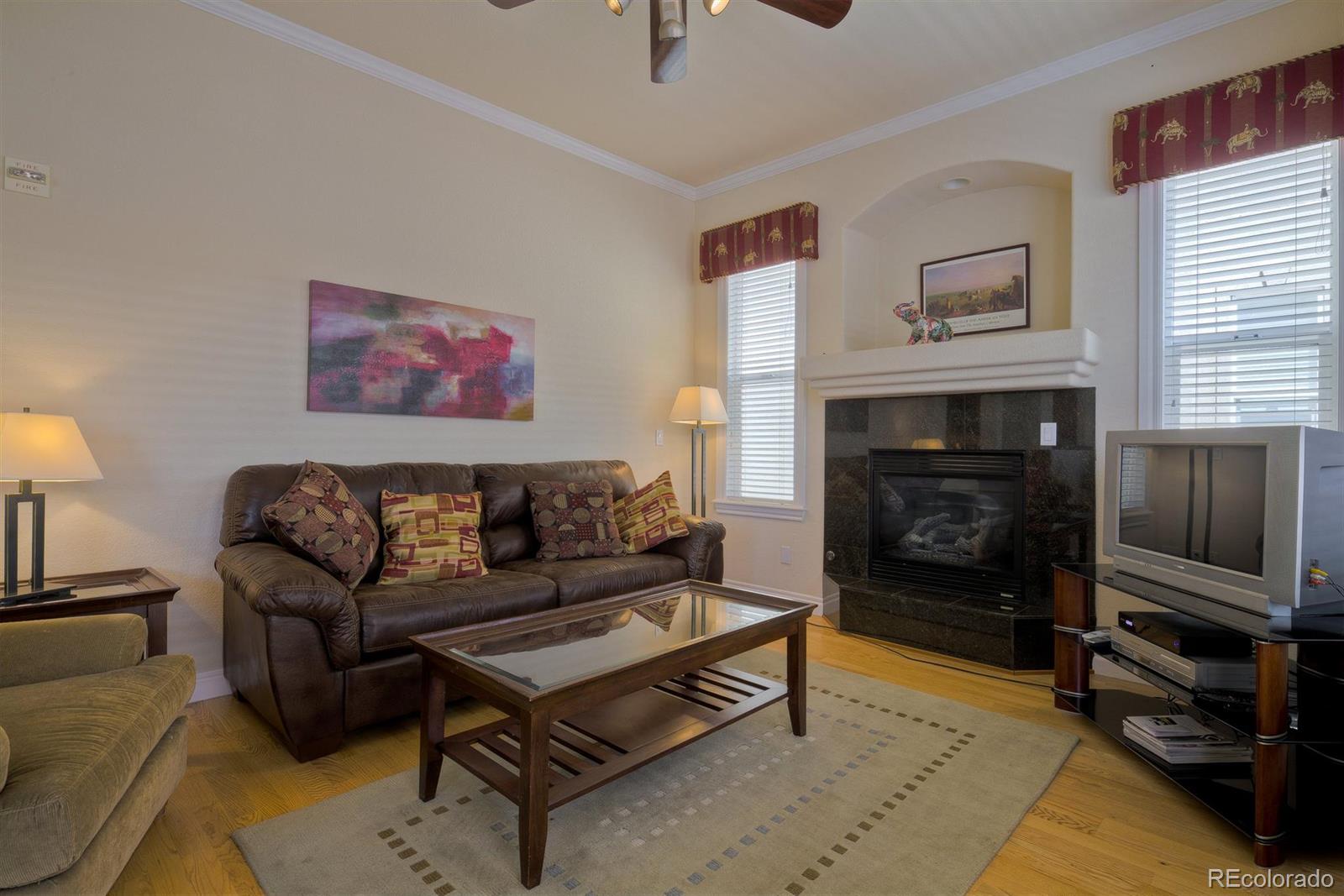 40 Madison Street, Unit 208 Denver, CO 80206 - Photo 5 of 20 a living room with furniture a flat screen tv and a fireplace