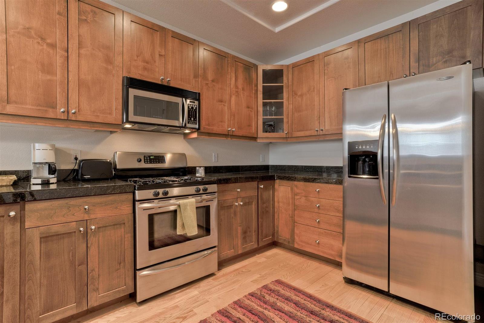 40 Madison Street, Unit 208 Denver, CO 80206 - Photo 9 of 20 a kitchen with stainless steel appliances granite countertop a refrigerator stove and microwave