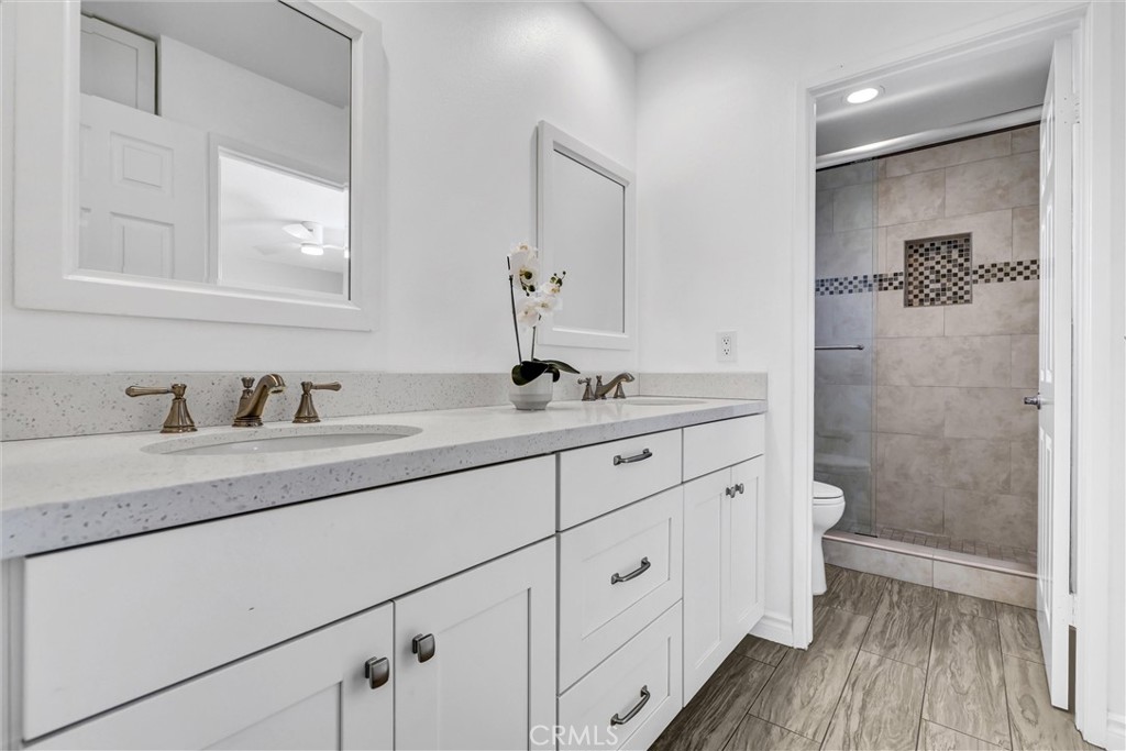 28661 Charreadas Laguna Niguel, CA 92677 - Photo 19 of 29 a bathroom with a granite countertop sink a toilet and a mirror