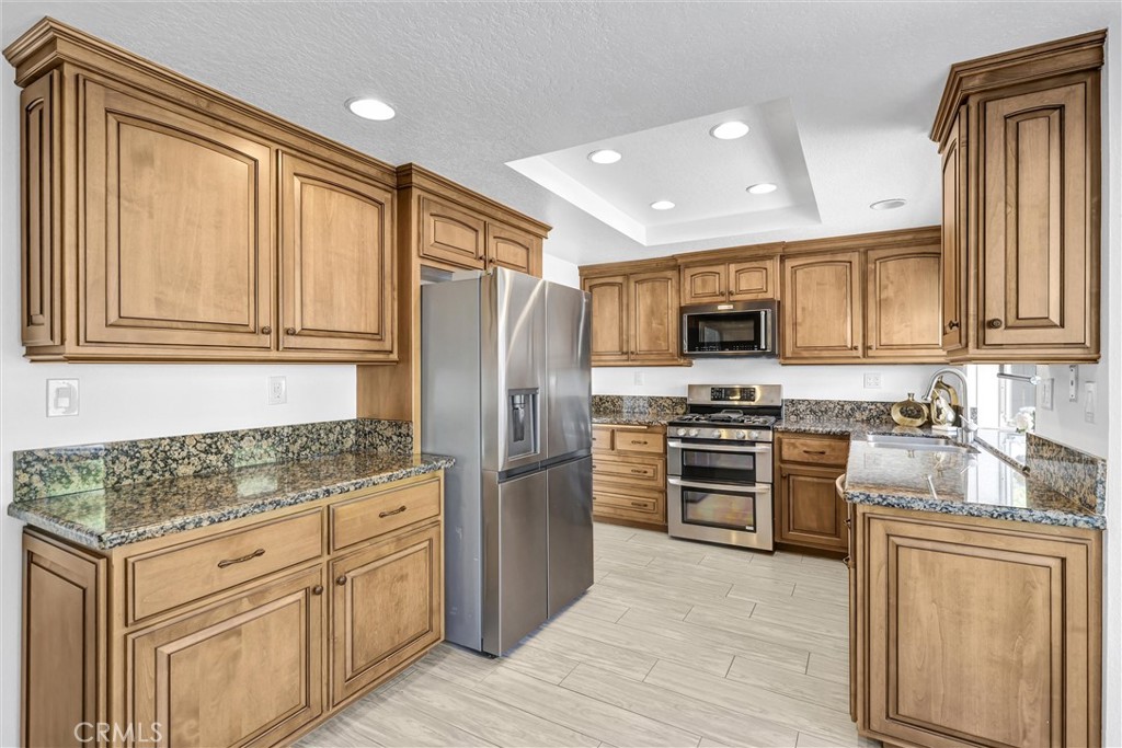 28661 Charreadas Laguna Niguel, CA 92677 - Photo 5 of 29 a kitchen with granite countertop cabinets stainless steel appliances and a wooden floor