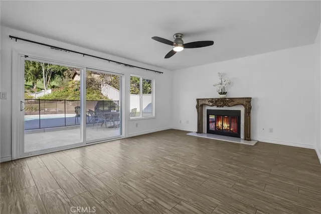 wooden floor fireplace and windows in an empty room