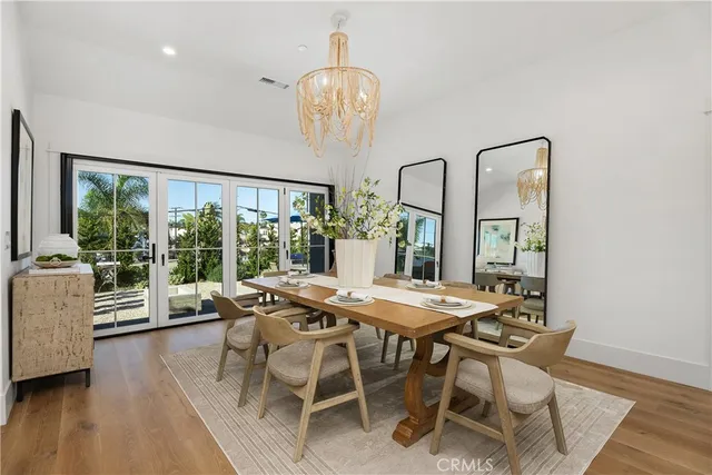 a dining room with furniture a chandelier and wooden floor