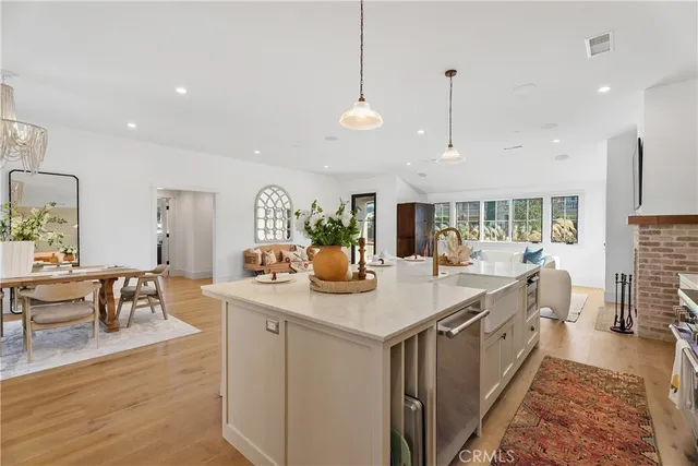 a view of a kitchen with kitchen island stainless steel appliances a dining table and chairs
