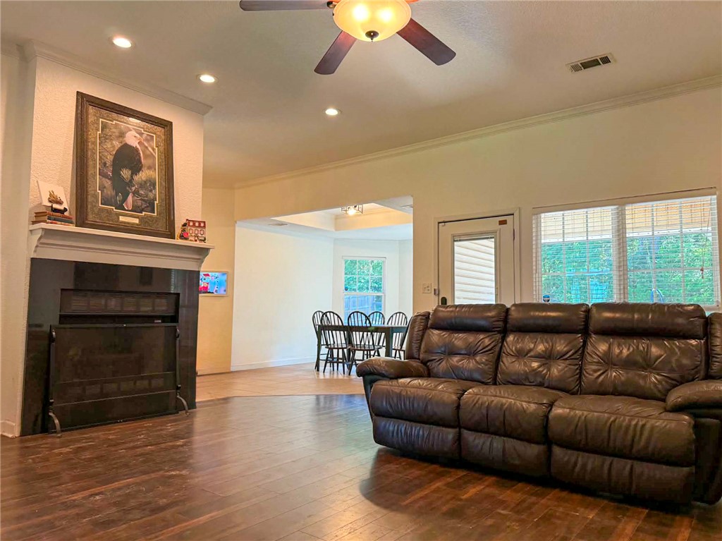 70 Walthall Road Russellville, AR 72802 - Photo 3 of 51 Living room featuring wood-finish flooring, a fireplace with a black surround and white mantel, and recessed lighting