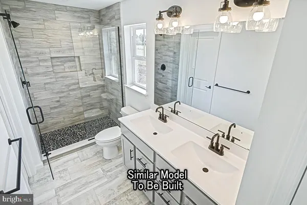 a bathroom with a sink a toilet a mirror and shower
