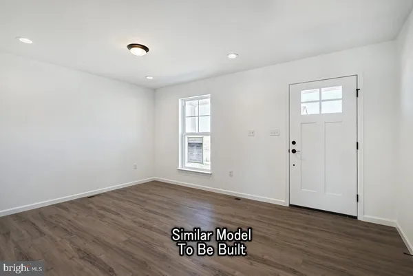 an empty room with wooden floor and window