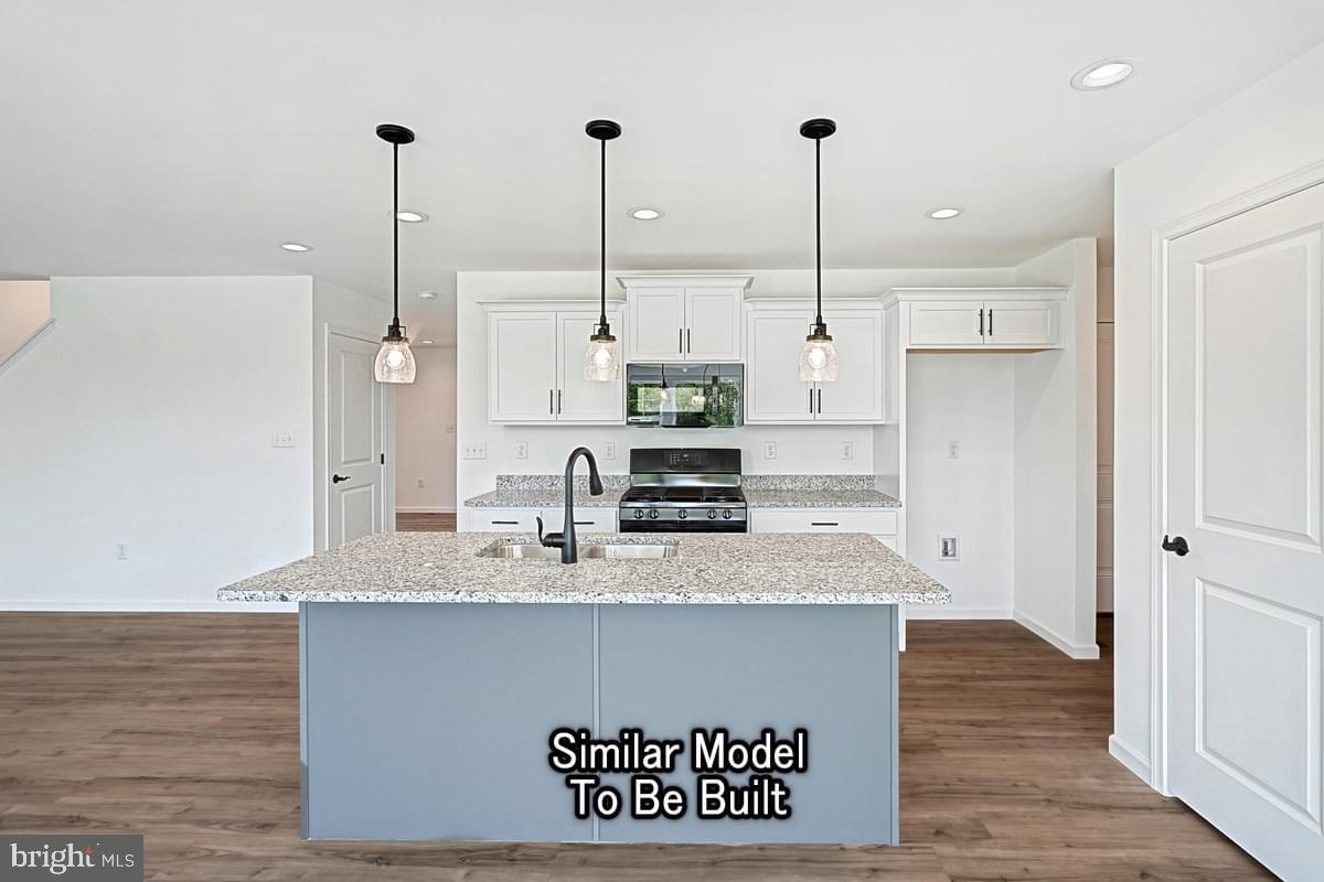 Meriwether Plan At The Seasons Dover, PA 17315 - Photo 9 of 30 a view of a kitchen with kitchen island stainless steel appliances wooden floor