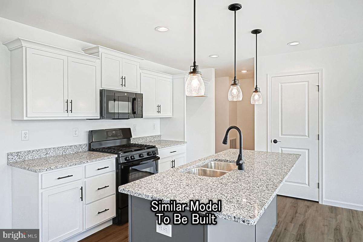 Meriwether Plan At The Seasons Dover, PA 17315 - Photo 10 of 30 a kitchen with granite countertop a stove a sink and a refrigerator