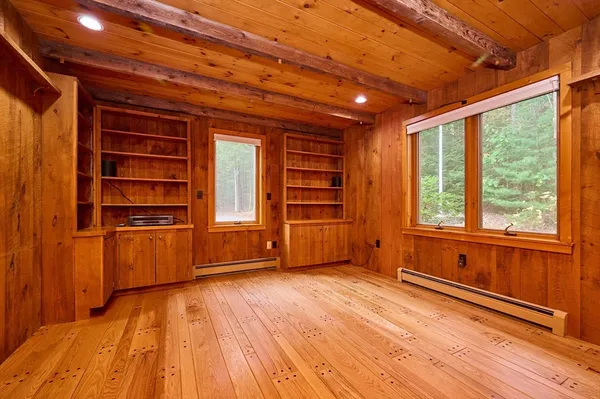 a view of empty room with a fireplace and wooden floor
