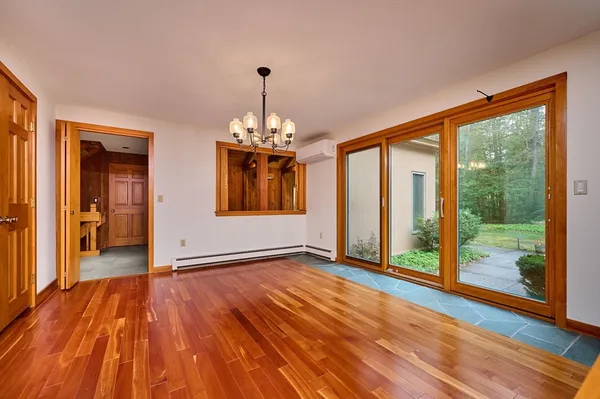 a view of an empty room with a fireplace and a chandelier