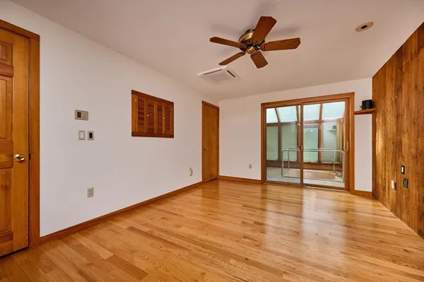 a view of an empty room with window and wooden floor