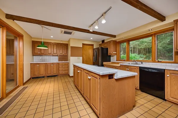 a dining hall with stainless steel appliances granite countertop a stove refrigerator and cabinets