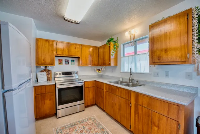a kitchen with stainless steel appliances granite countertop a sink stove and refrigerator