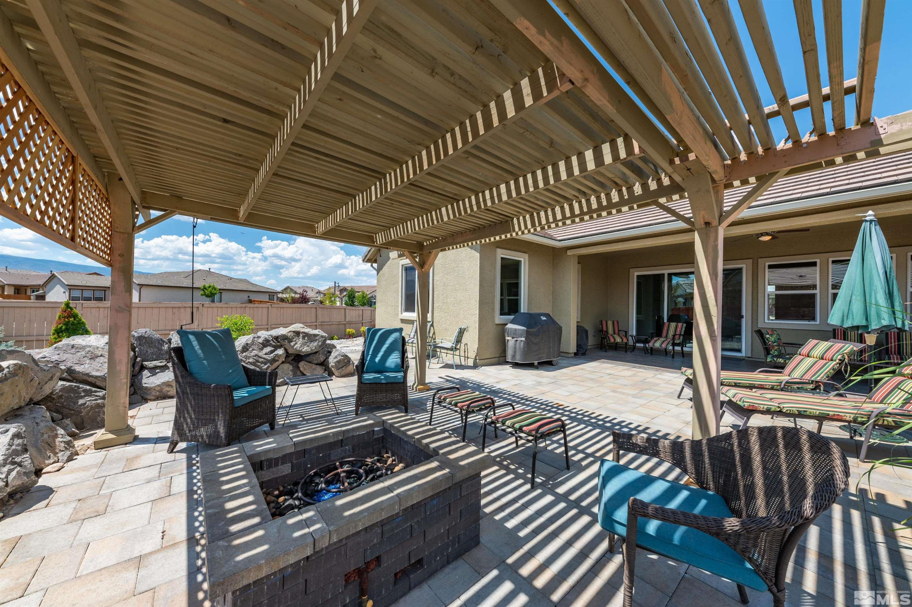 2084 Phaethon Lane Reno, NV 89521 - Photo 21 of 35 a view of a patio with table and chairs barbeque potted plants and large tree