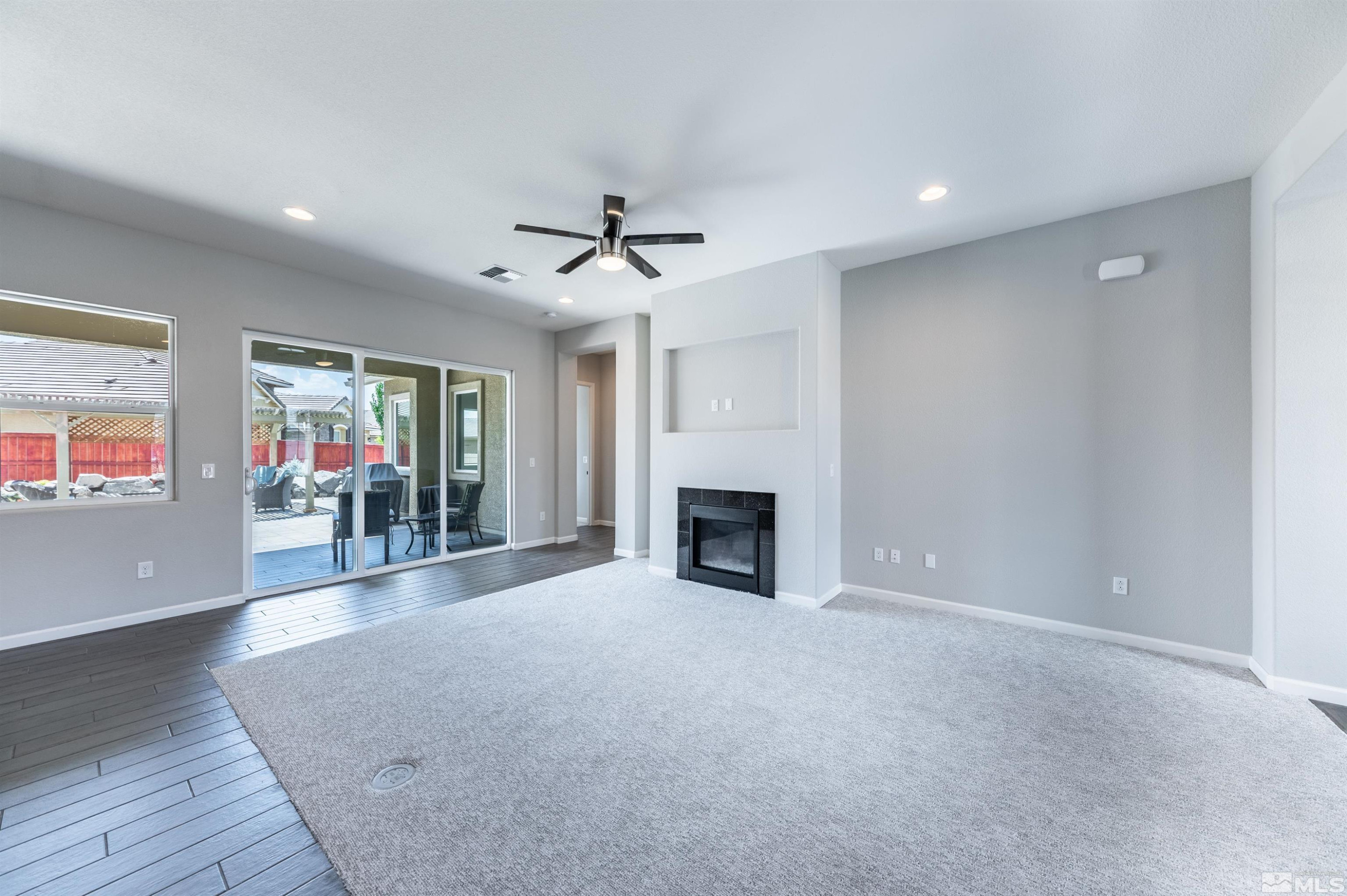 2084 Phaethon Lane Reno, NV 89521 - Photo 5 of 35 an empty room with furniture wooden floor fireplace and windows