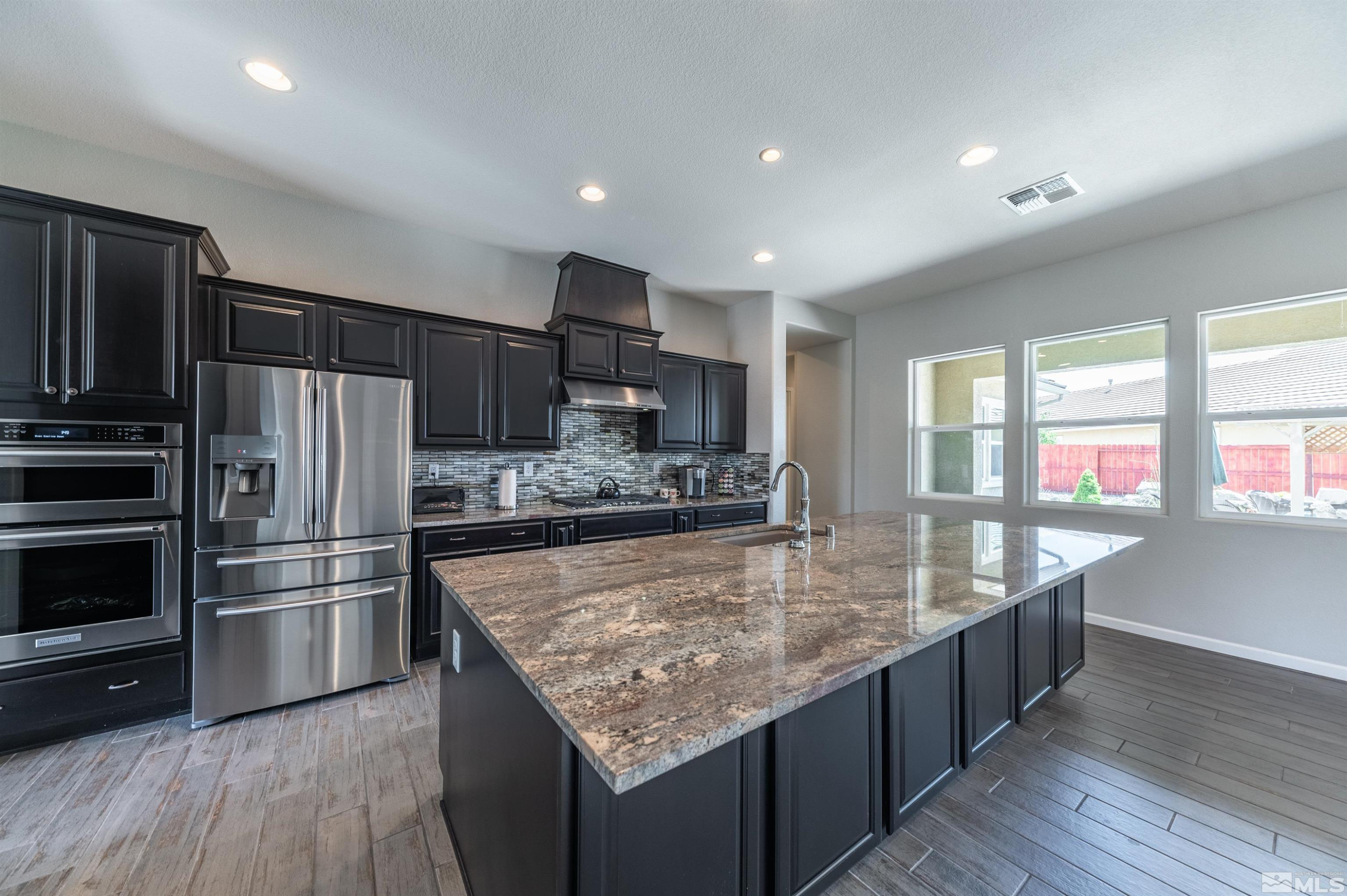2084 Phaethon Lane Reno, NV 89521 - Photo 7 of 35 a large kitchen with kitchen island a large counter top and stainless steel appliances