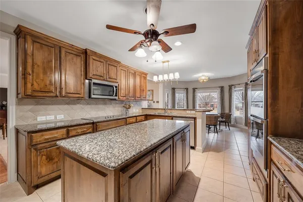 a kitchen with stainless steel appliances granite countertop a sink dishwasher stove and microwave oven with cabinets