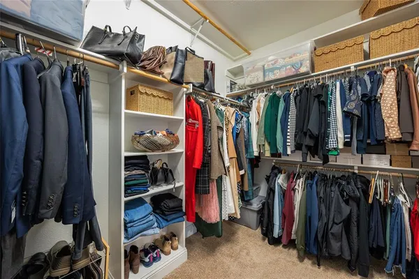 a view of walk in closet with clothes and shoes