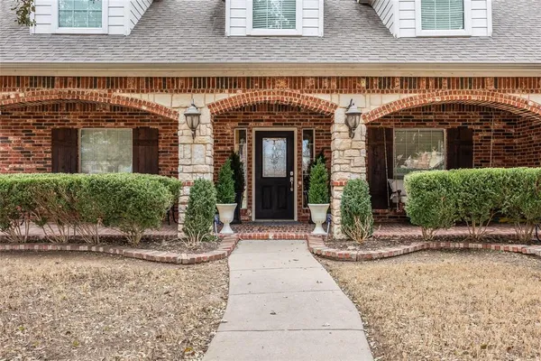 front view of a brick house with a small yard