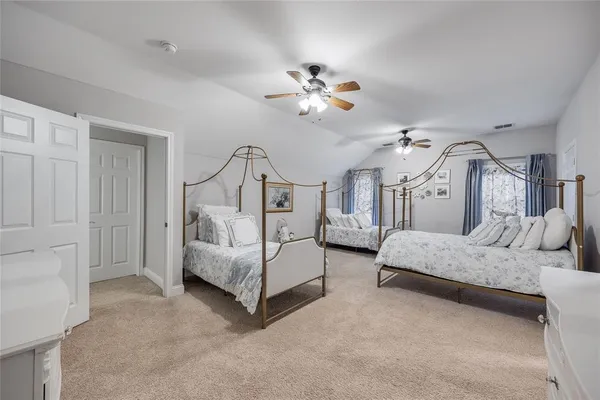 a spacious bedroom with a bed and ceiling fan