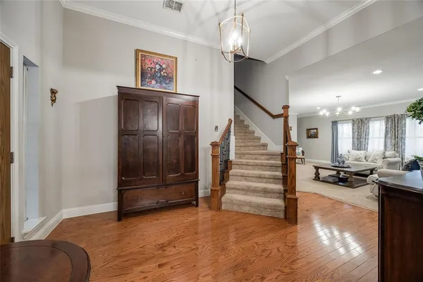 a view of a hallway with stairs and furniture