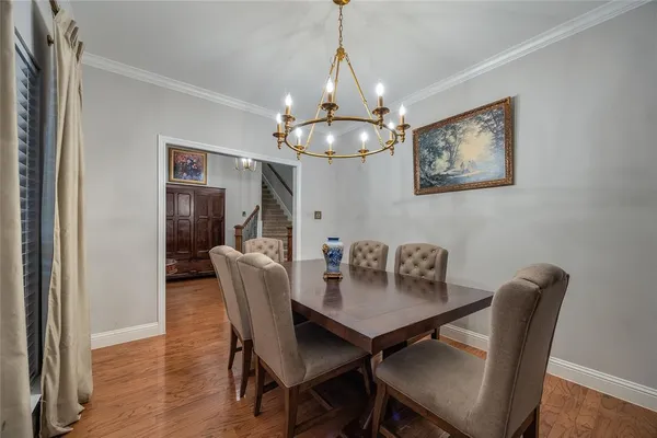 a dining room with furniture a chandelier and wooden floor