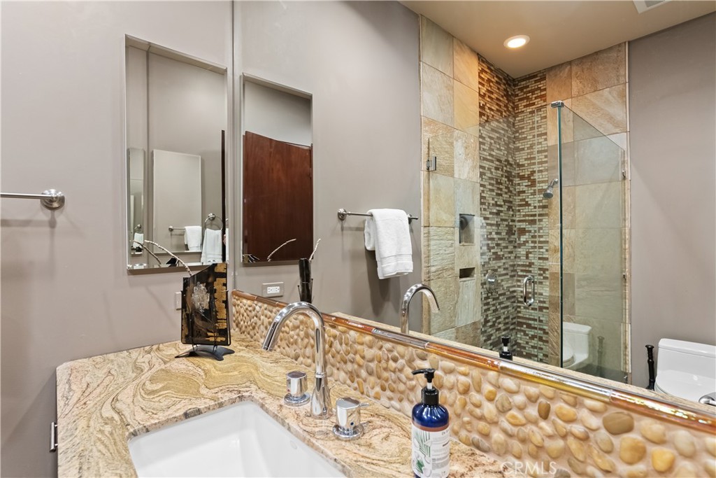 68 Royal St Georges Way Rancho Mirage, CA 92270 - Photo 67 of 75 a bathroom with a granite countertop sink a mirror and shower