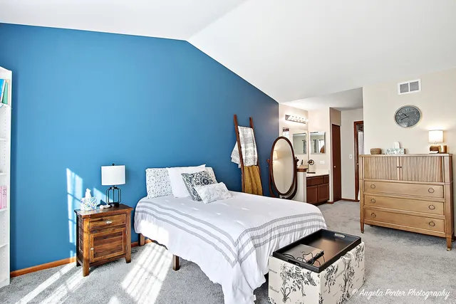 a large bed sitting in a room next to a window and mirror