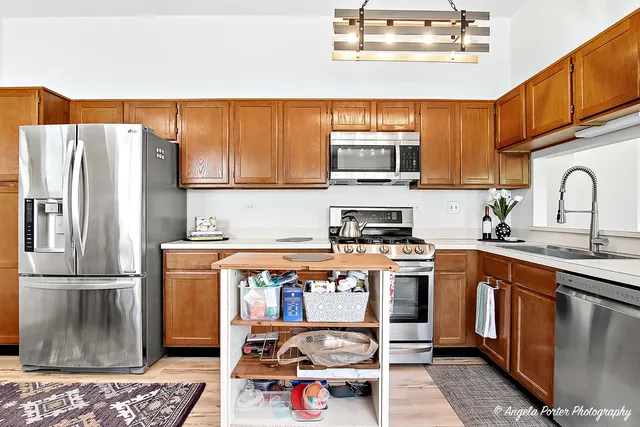 a kitchen with stainless steel appliances granite countertop a refrigerator a stove a sink and a microwave