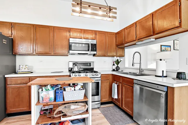 a kitchen with stainless steel appliances granite countertop a sink stove and cabinets