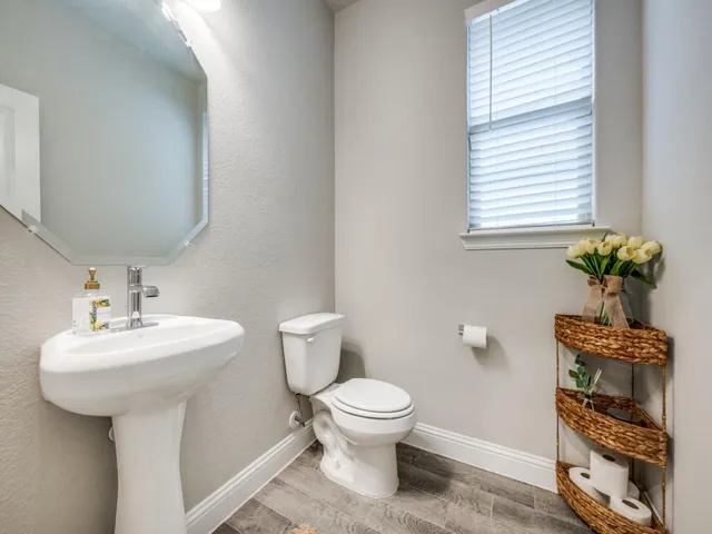 a bathroom with a sink toilet and a mirror