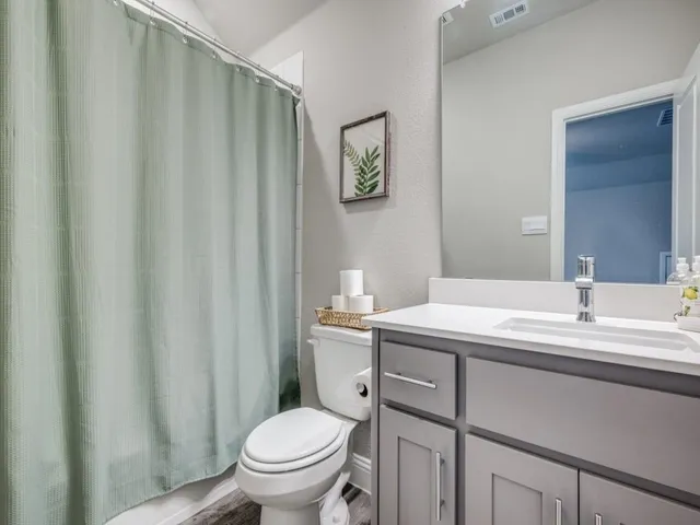 a bathroom with a granite countertop sink toilet and a mirror