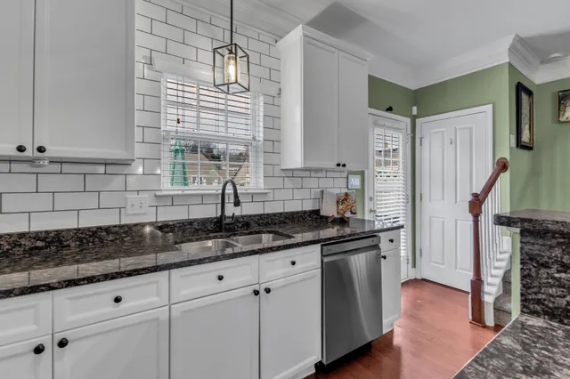 a kitchen with stainless steel appliances granite countertop a sink a stove a refrigerator and cabinets