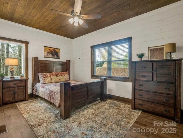a bedroom with a bed and a dresser next to a window