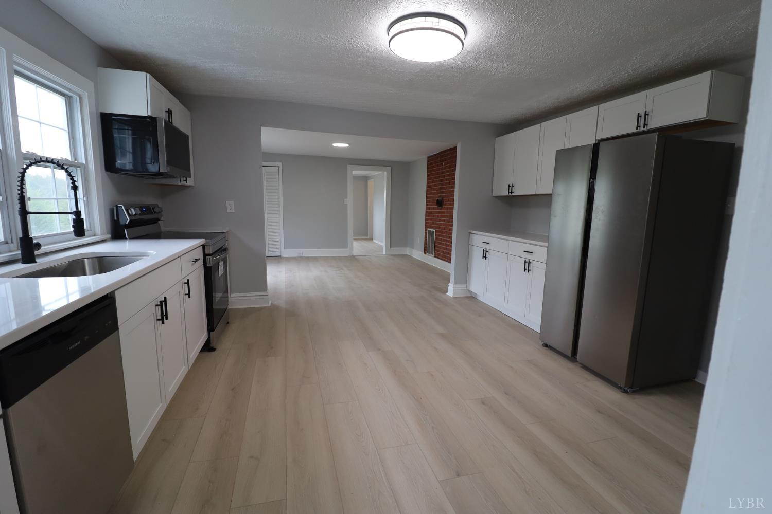 2079 Pin Oak Road Prospect, VA 23960 - Photo 2 of 8 a kitchen with a sink a refrigerator a stove top oven and wooden floor
