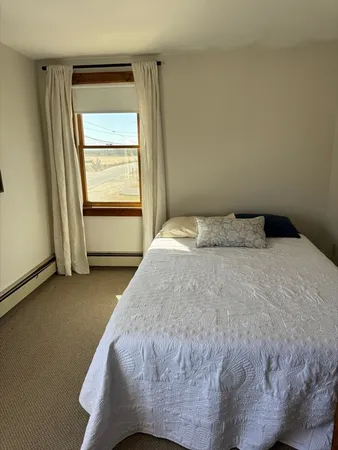 a bed sitting in a bedroom next to a window