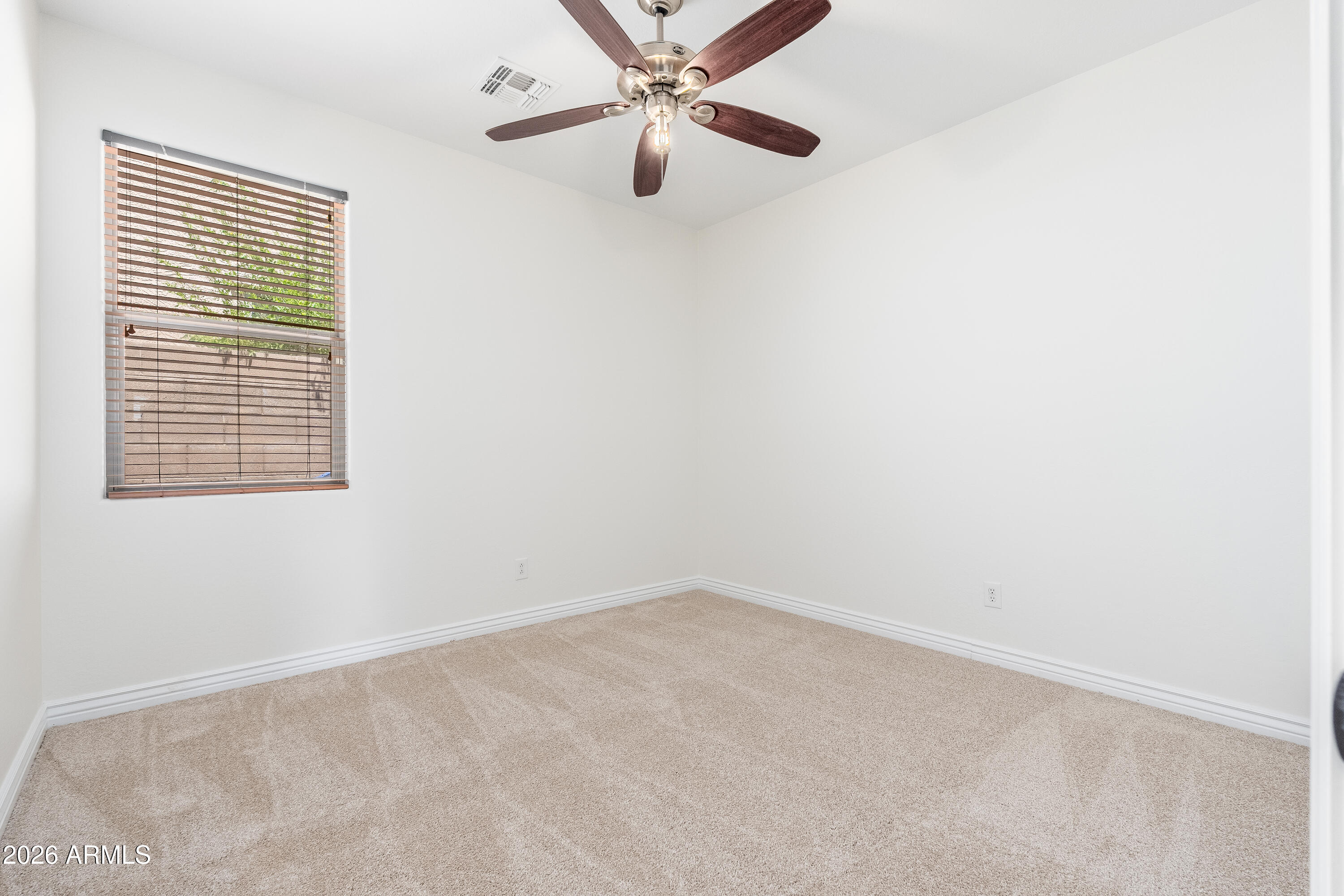4317 East Folgers Road Phoenix, AZ 85050 - Photo 19 of 40 an empty room with a window and a ceiling fan