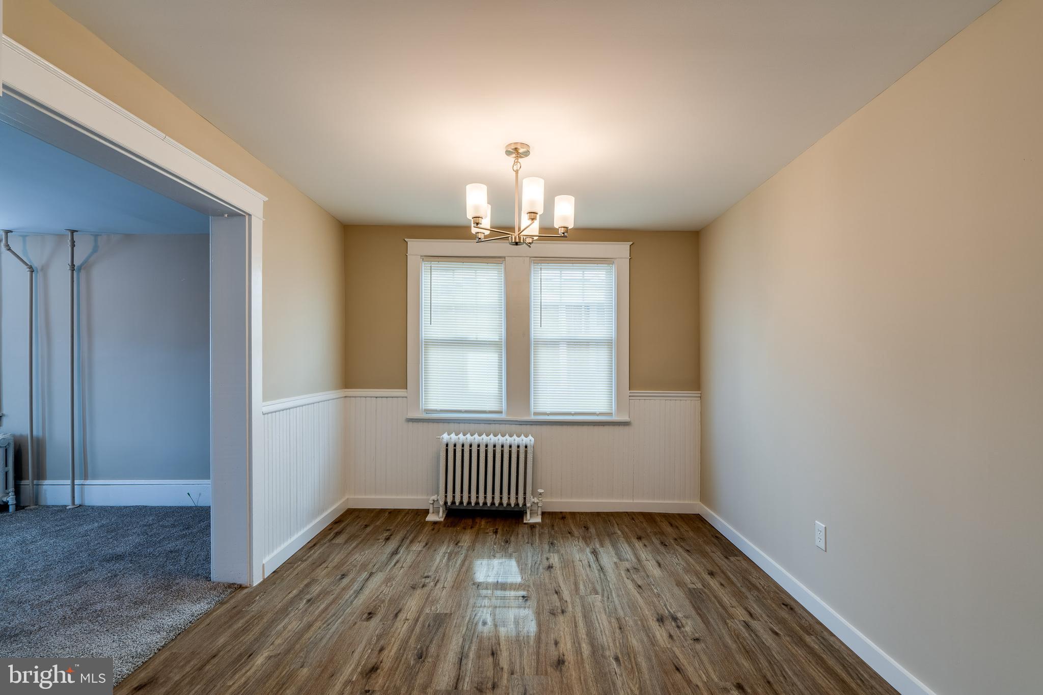 309 South Cherry Street Manheim, PA 17545 - Photo 16 of 34 an empty room with wooden floor exposed radiator and windows