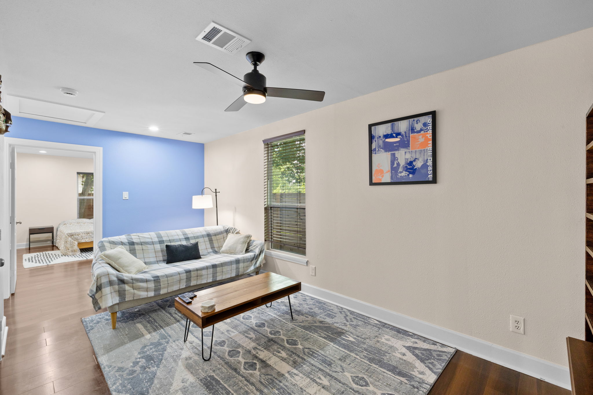 907 East 53rd Street Austin, TX 78751 - Photo 17 of 36 A relaxed living space with a large area rug, a ceiling fan, and hardwood floors.