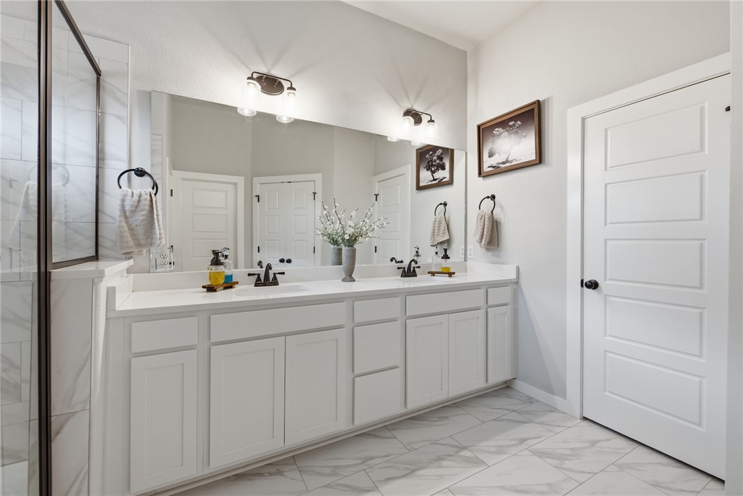 3112 Margaret Rudder Parkway Bryan, TX 77808 - Photo 14 of 24 a bathroom with a double vanity sink and a mirror
