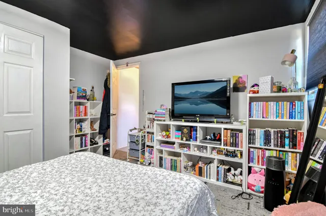 a bedroom with a bed and a book shelf