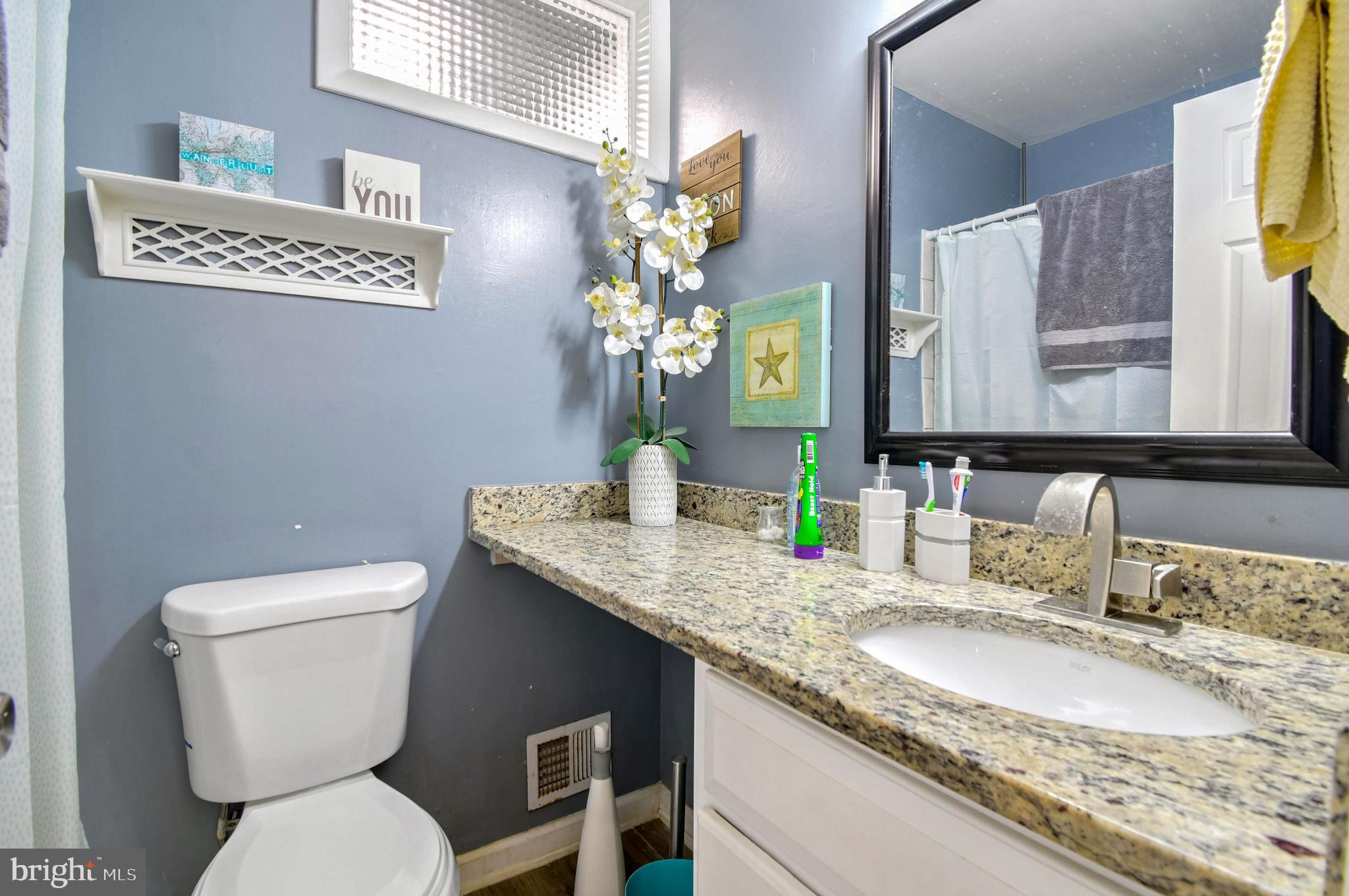 1104 Caddington Avenue Silver Spring, MD 20901 - Photo 9 of 23 a bathroom with a granite countertop toilet sink and mirror